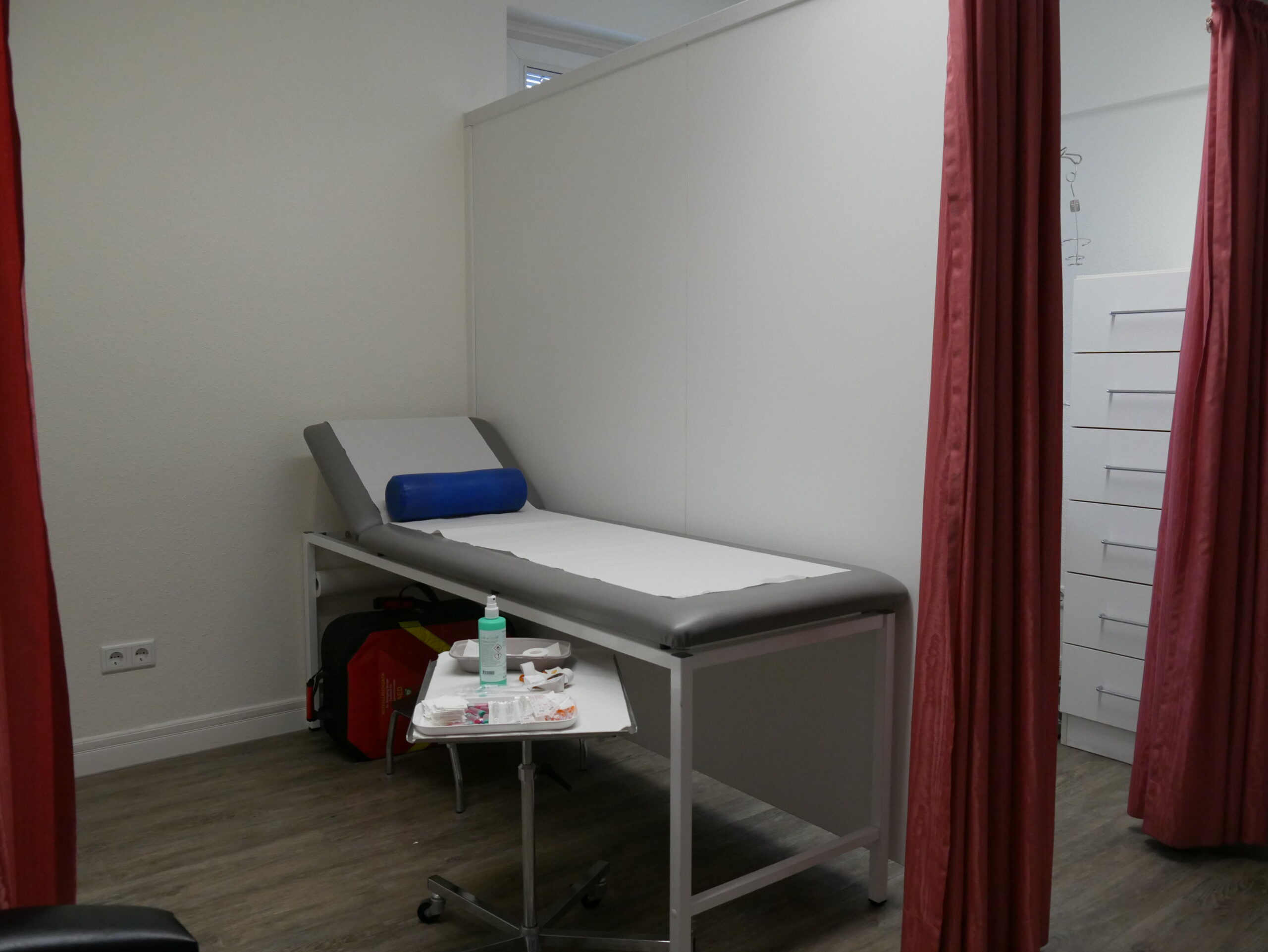 Untersuchungsliege in einem Behandlungsraum mit Trennvorhängen