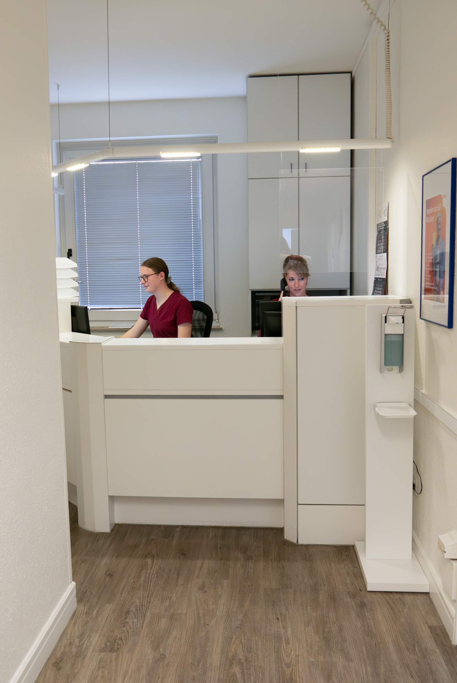 Empfangsbereich der Praxis Dr. Burger mit zwei Mitarbeiterinnen